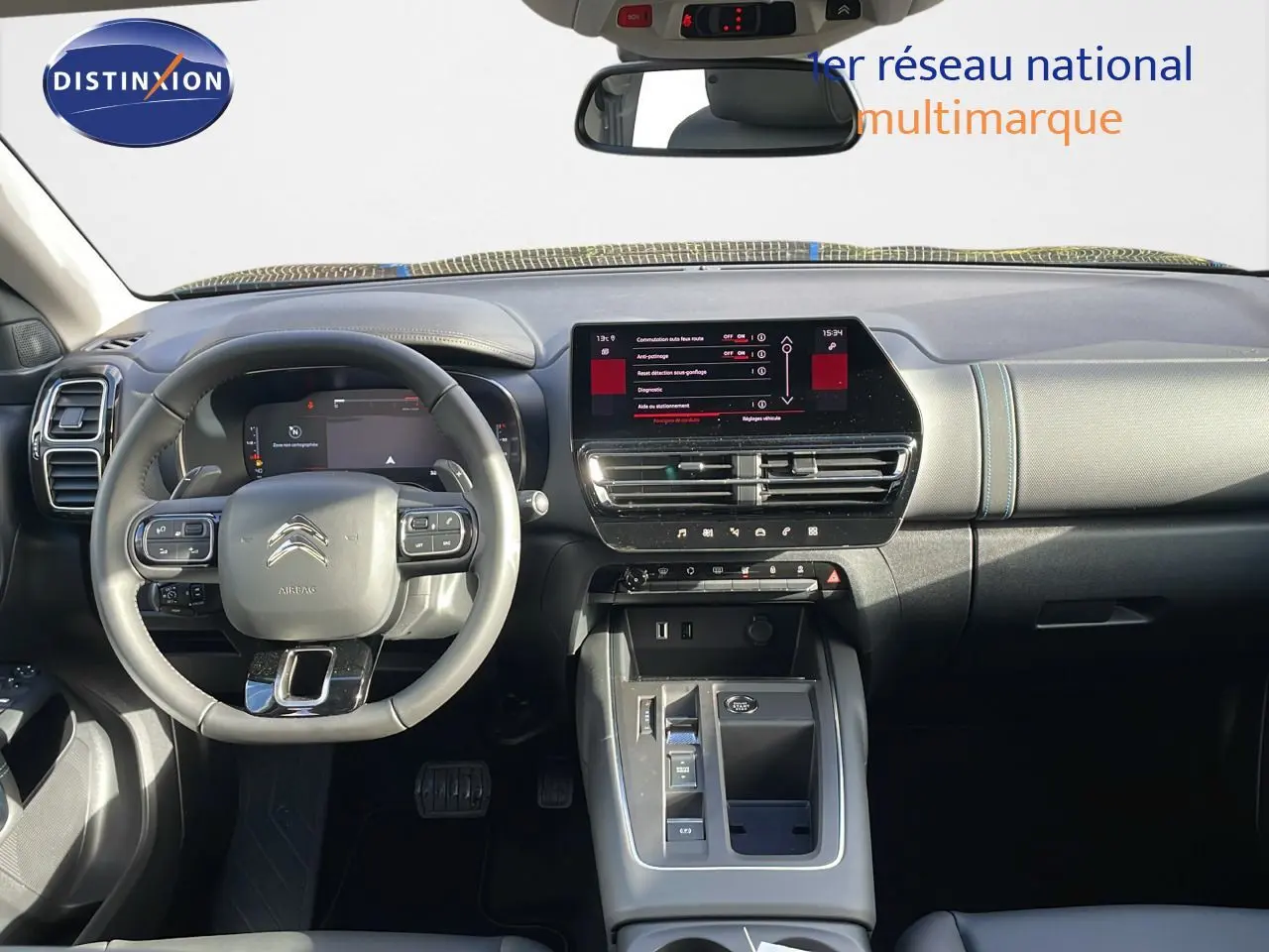 Vue intérieure avant du tableau de bord et du volant gris du Citroën C5 Aircross 2025 avec écran tactile central allumé.