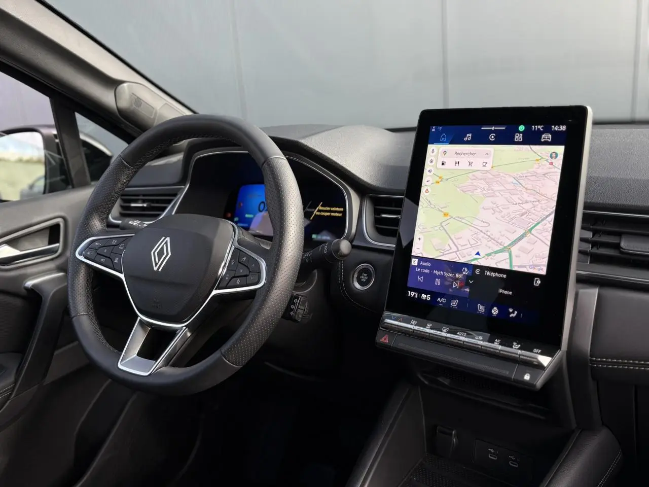 Vue intérieure côté conducteur du Renault SYMBIOZ 2025 avec volant multifonction et écran tactile vertical GPS.