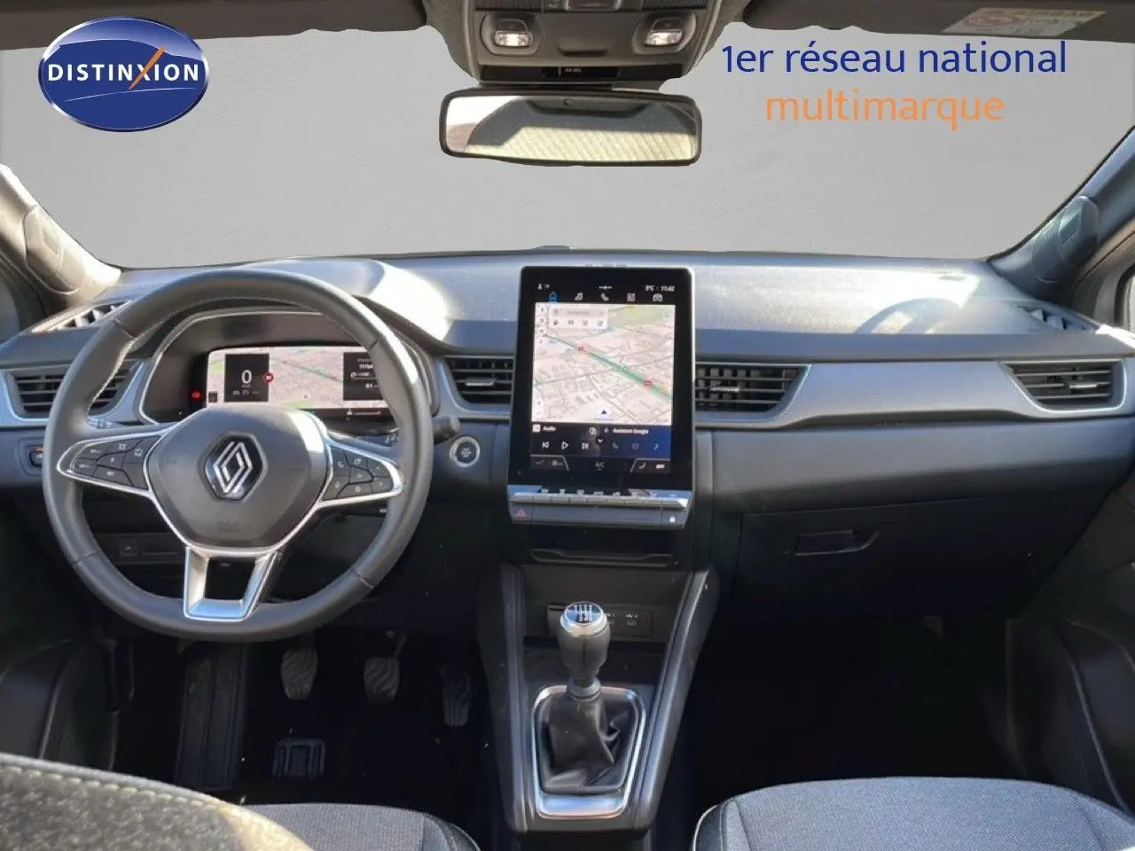 Vue intérieure avant du Renault Captur 2025 avec tableau de bord moderne, écran tactile vertical et levier de vitesses manuel.