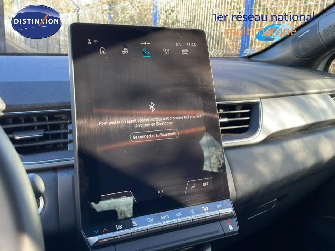 Vue intérieure centrée sur l'écran tactile du tableau de bord du Renault Captur gris Rafale métal avec toit noir.