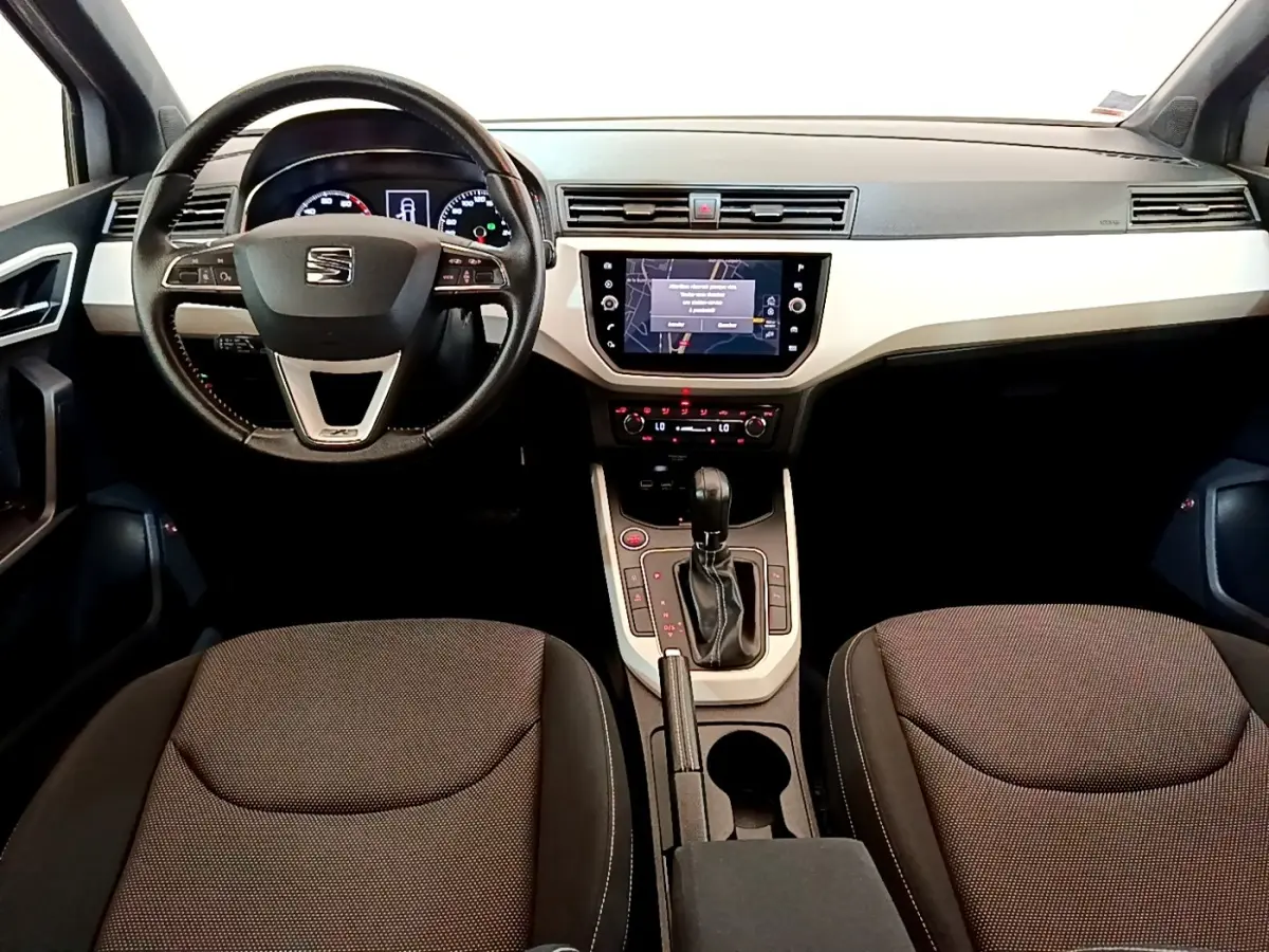 Intérieur avant du SEAT Arona 2019, vue centrée sur le volant cuir alu et l’écran tactile de navigation.