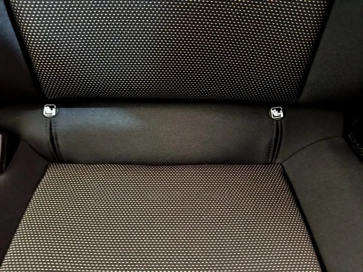 Gros plan sur la banquette arrière noire à motifs blancs du SEAT Arona, montrant les fixations Isofix.