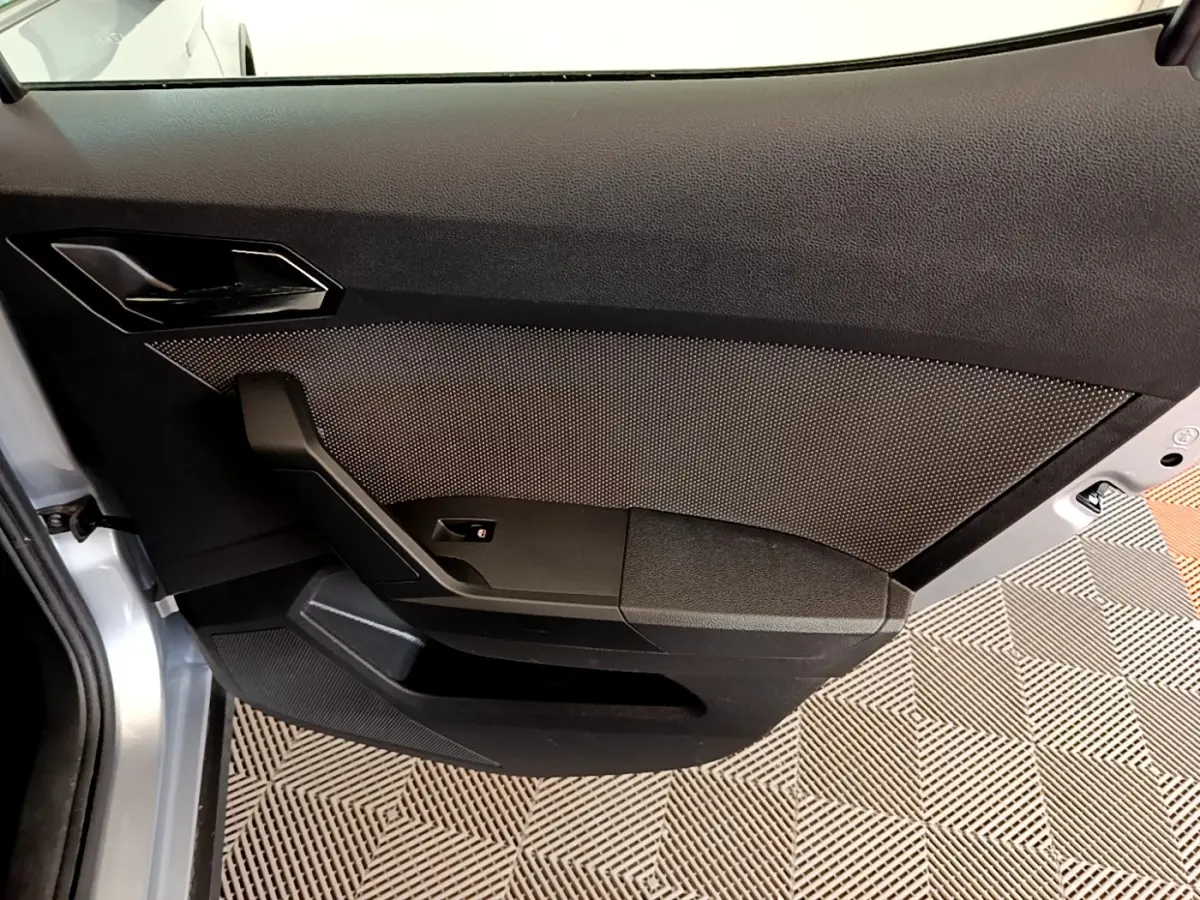 Vue intérieure du panneau de porte côté gauche gris foncé du SEAT Arona 2019 avec texture et poignée intégrée.