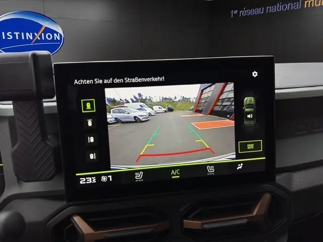 Écran tactile intérieur du Dacia Duster 2025 affichant la caméra de recul avec vue arrière sur un parking.