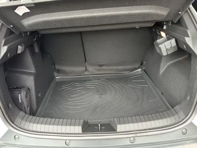 Coffre ouvert du Dacia Duster 2025 avec tapis de sol noir texturé, montrant l'espace de chargement intérieur.