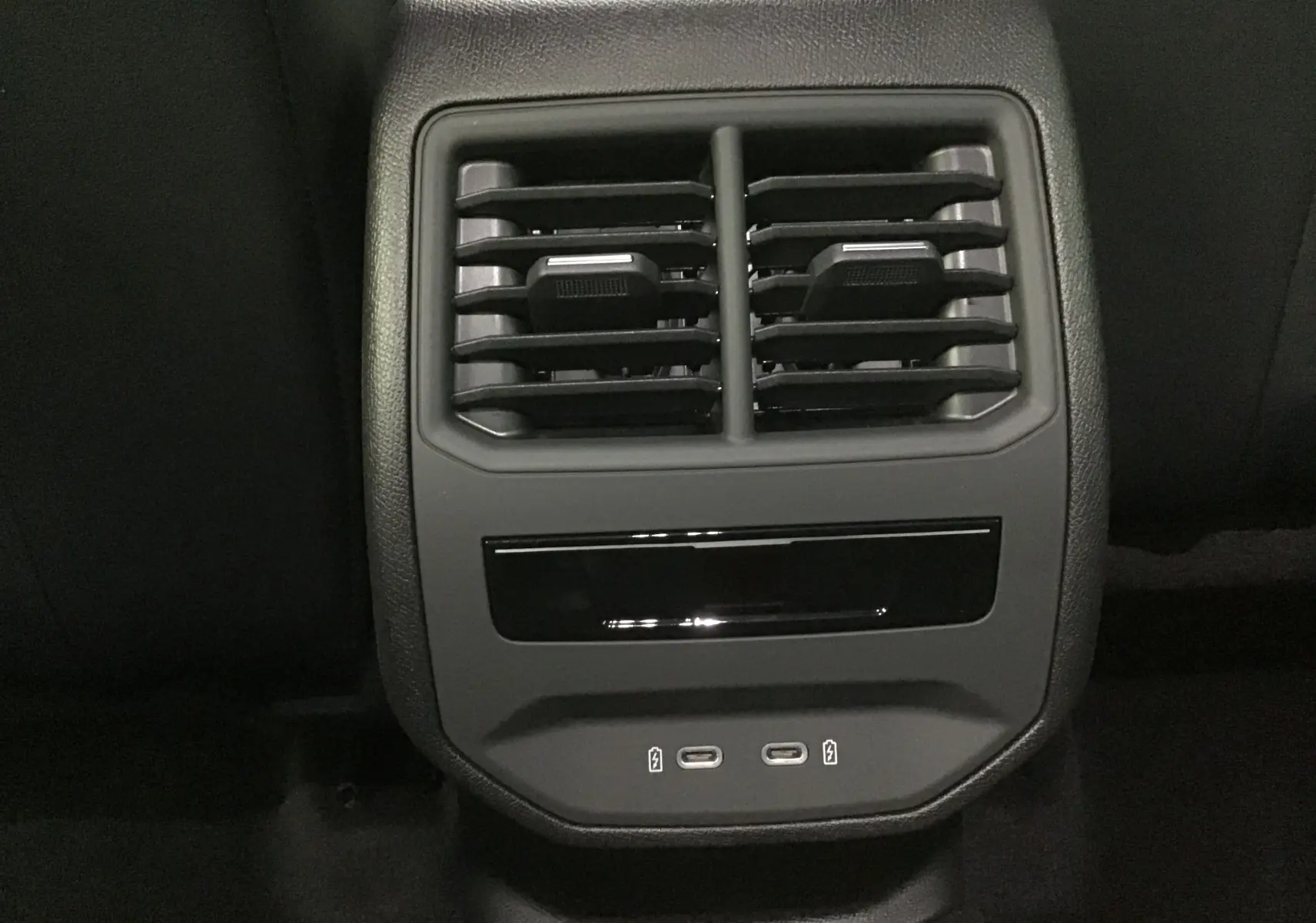 Vue rapprochée des aérateurs arrière et des ports USB-C noirs dans l'habitacle d'une CUPRA Leon 2023 noire.