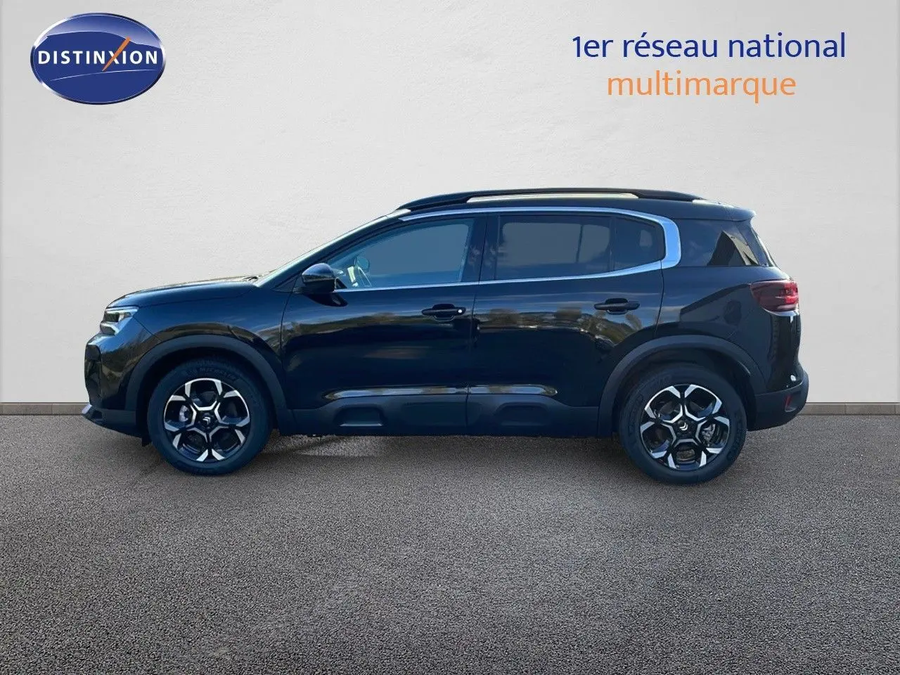 Profil latéral droit d'un Citroën C5 Aircross noir Perla Metal avec jantes bi-ton et barres de toit visibles.