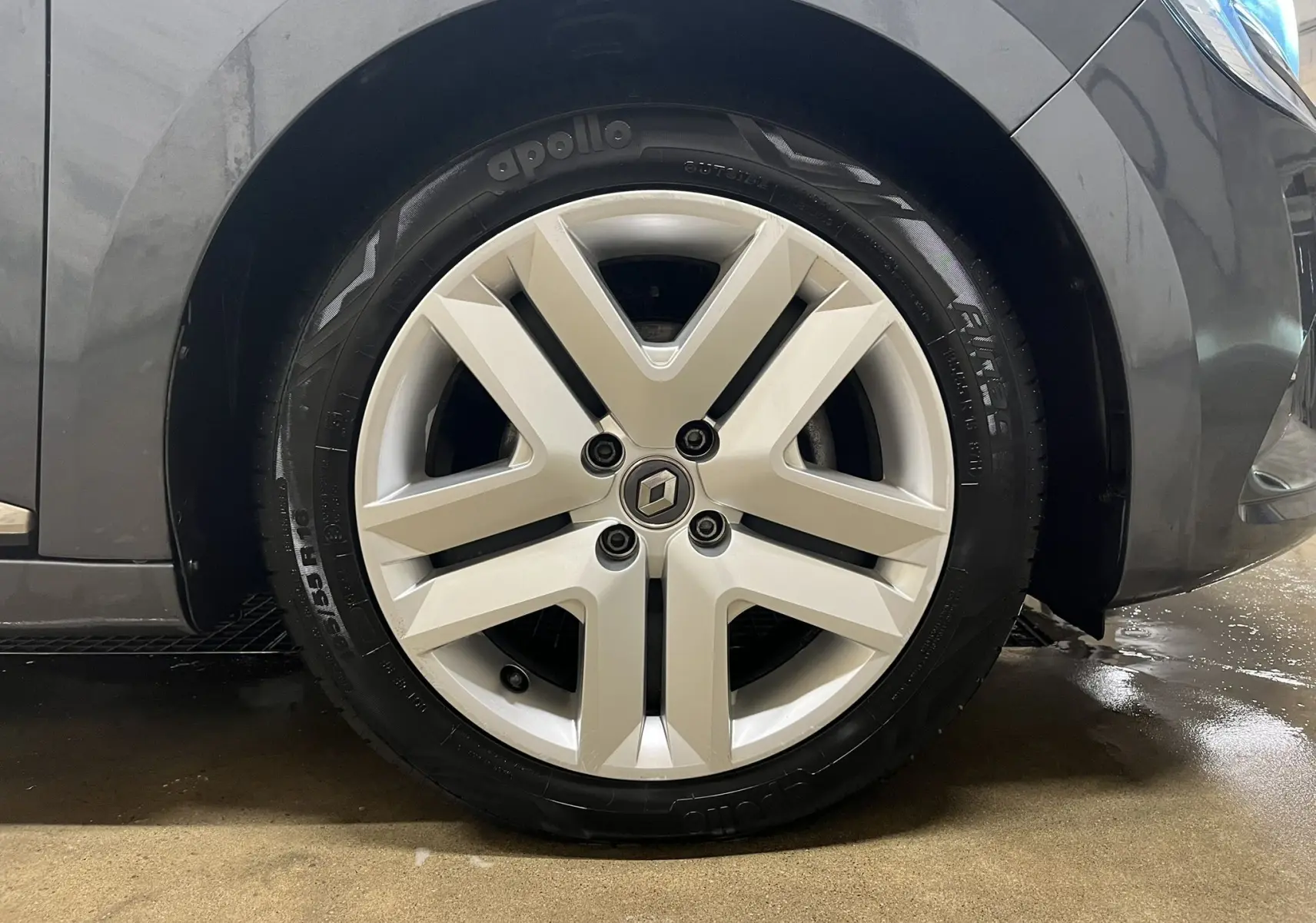 Gros plan sur la roue avant droite d'une Renault Clio V Business gris titanium avec jante alliage distinctive.