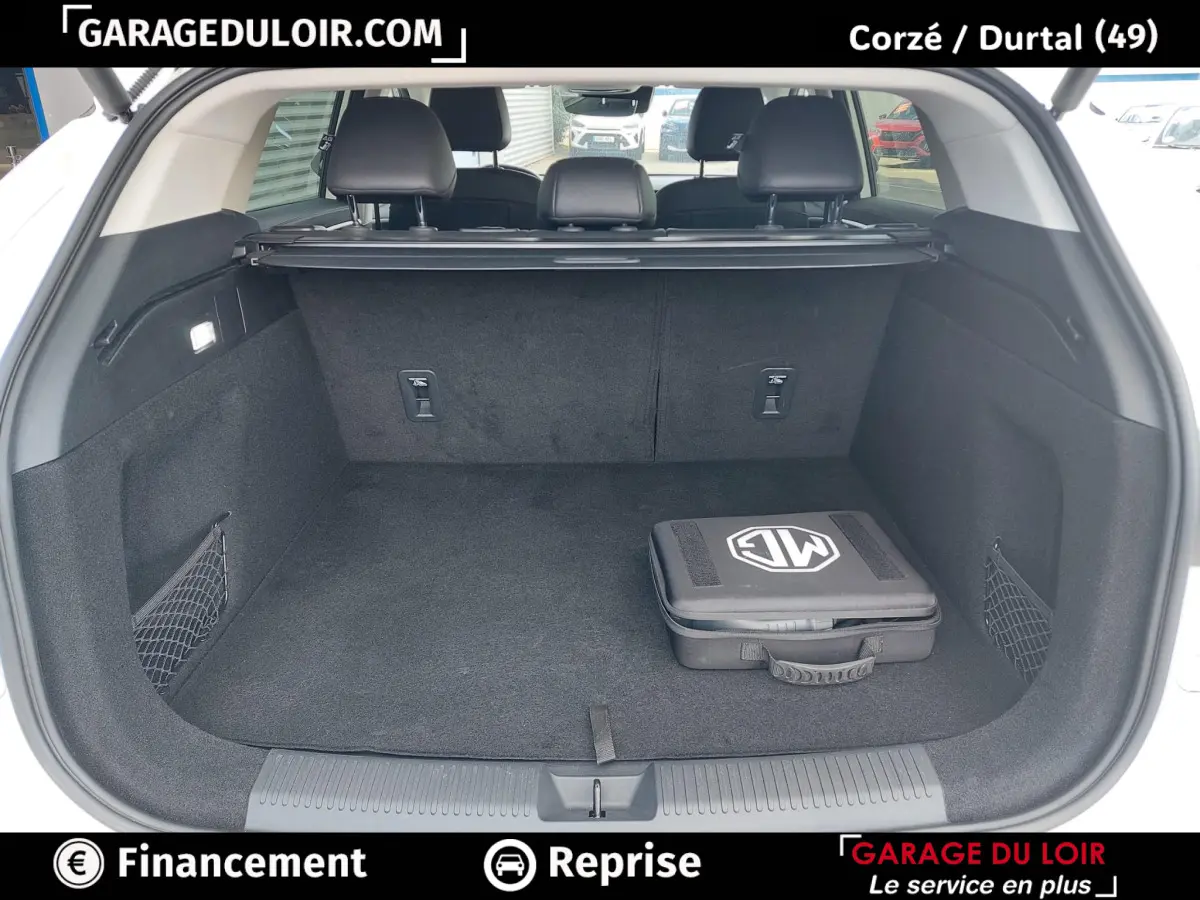 Coffre ouvert noir d’un MG Motor EHS hybride rechargeable 2025, avec housse de rangement siglée MG visible.