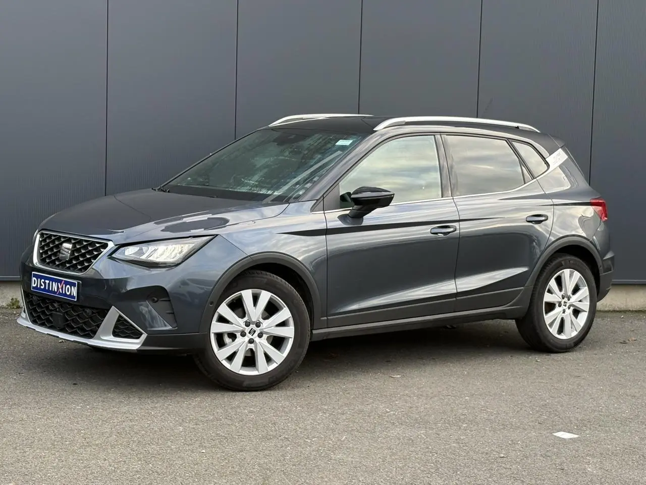 SEAT Arona TSI 115 DSG Xpérience gris magnétique en 3/4 avant droit avec toit contrasté et jantes alliage 17 pouces.
