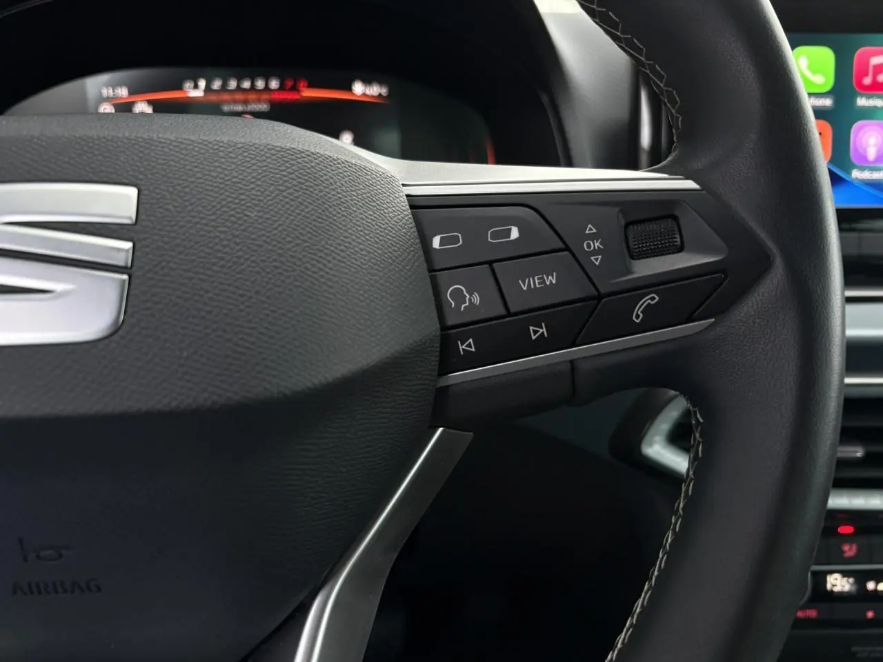 Gros plan sur le volant noir du SEAT Arona 2025 avec commandes multifonctions et combiné digital en arrière-plan.