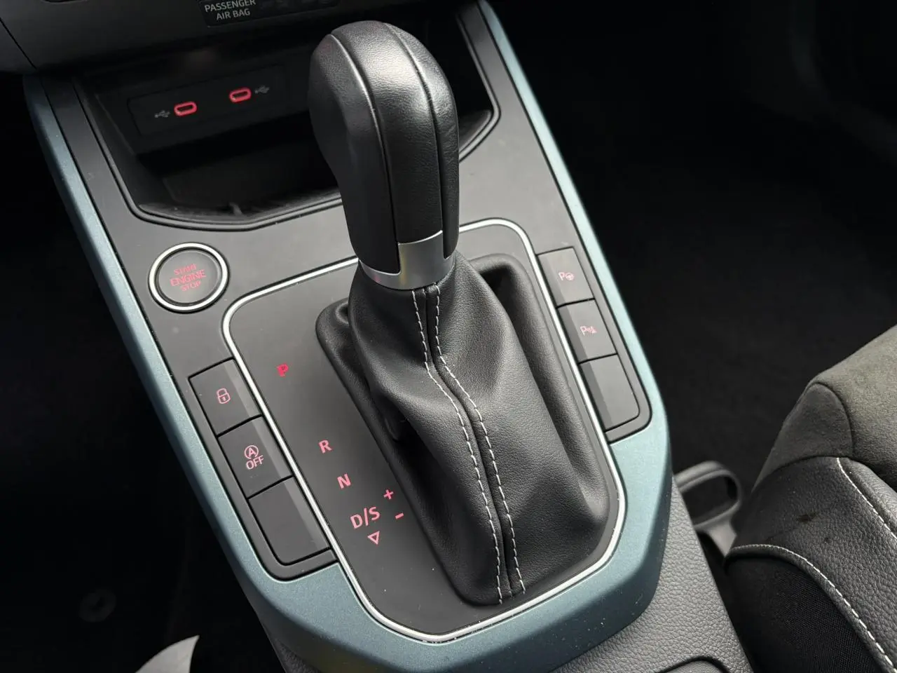 Gros plan sur la console centrale de la SEAT Arona 2025, avec levier de vitesse automatique en cuir noir et cadre gris magnétique.