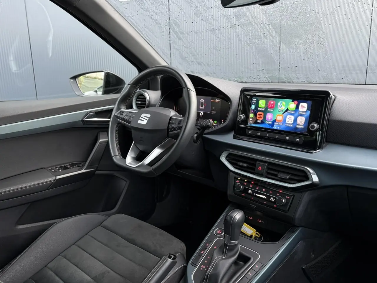 Vue intérieure côté conducteur du SEAT Arona 2025 avec tableau de bord digital et écran tactile central.