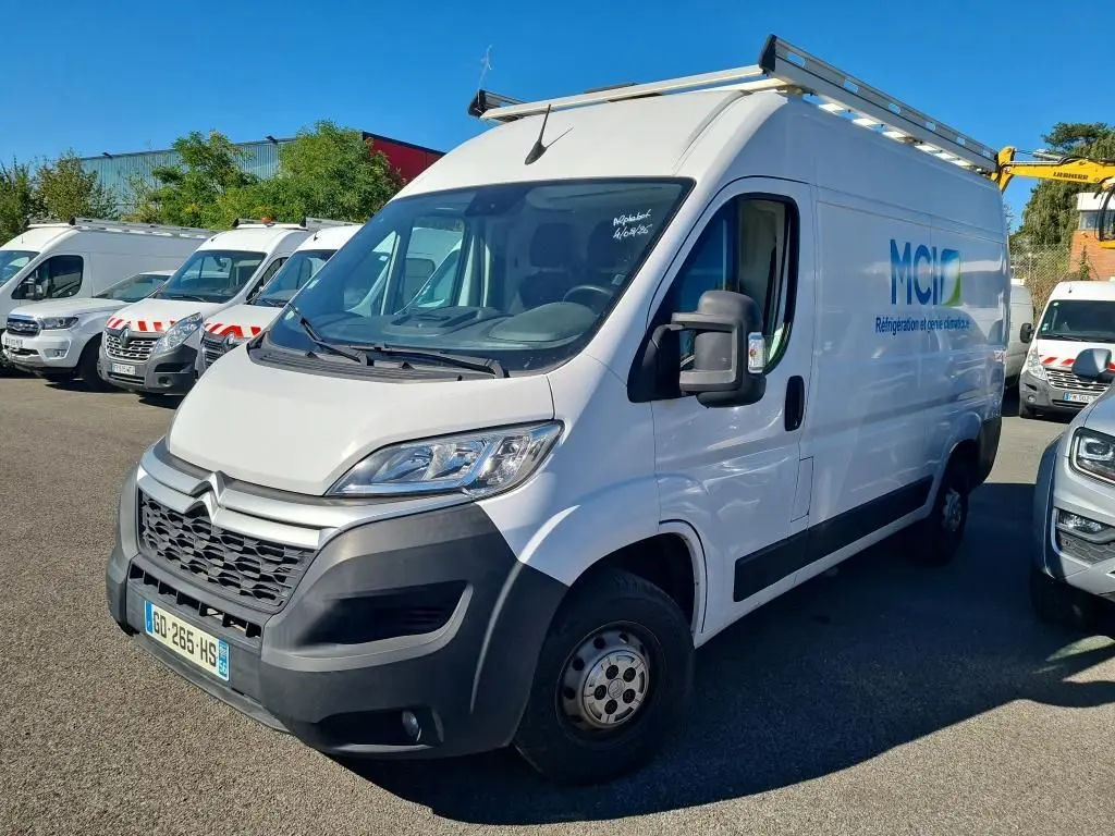 Fourgon Citroën Jumper blanc en vue 3/4 avant droit avec galerie et logo MCI sur la porte latérale.