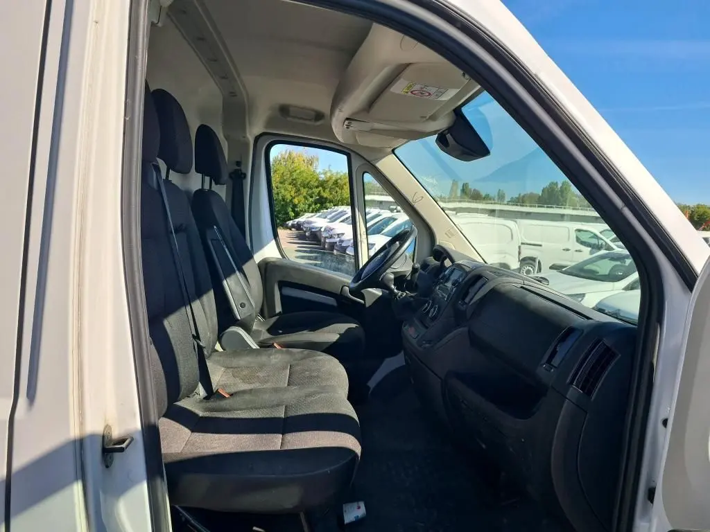 Vue intérieure côté conducteur du Citroën Jumper blanc 2021, montrant les sièges avant et le tableau de bord.