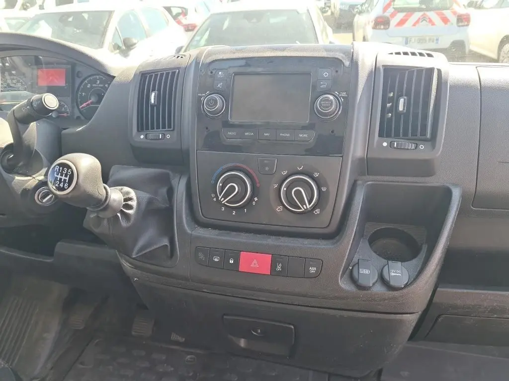 Vue intérieure du tableau de bord du Citroën Jumper blanc 2021, avec levier de vitesse manuel et commandes climatisation visibles.