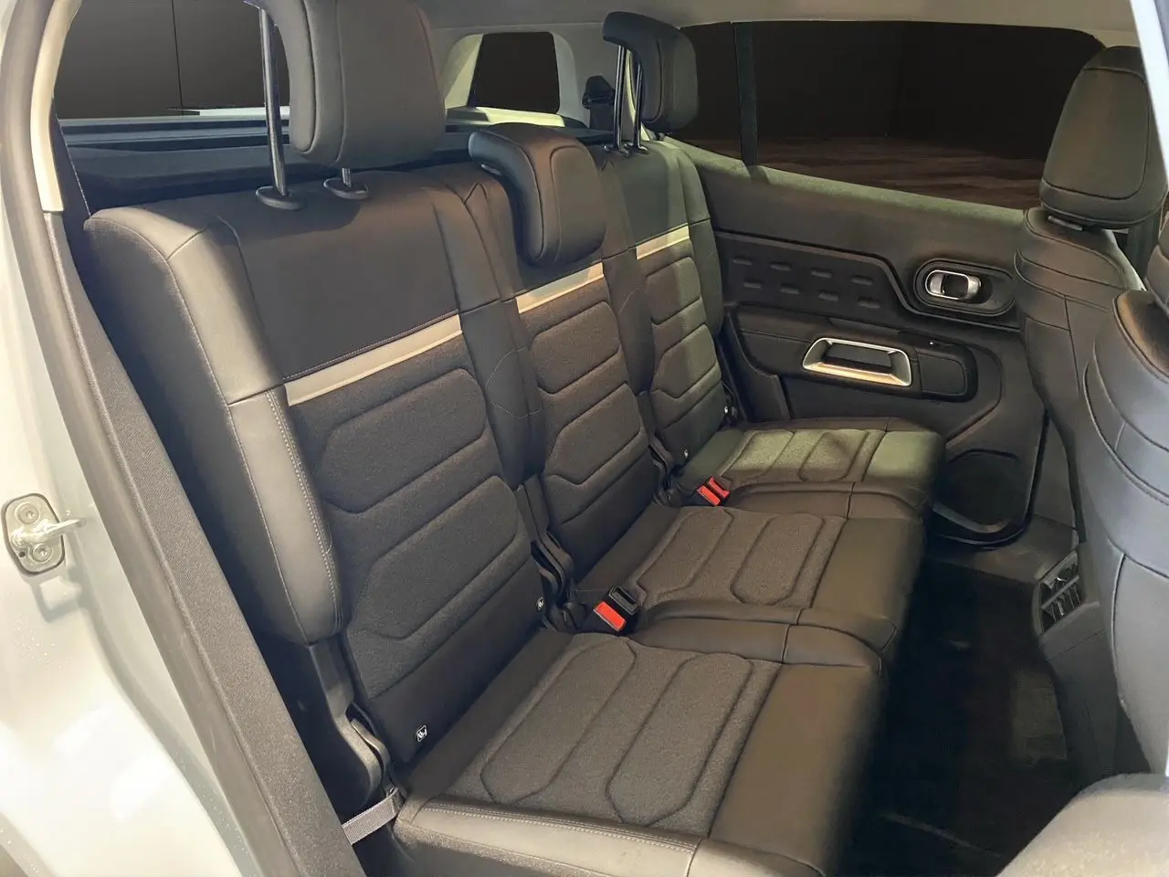 Vue intérieure côté droit des sièges arrière noirs en tissu et cuir du Citroën C5 Aircross 2024 blanc/noir.