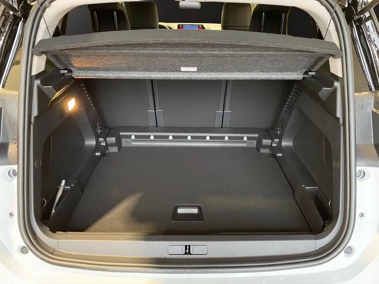 Coffre ouvert du Citroën C5 Aircross blanc/noir 2024, vue arrière montrant l'espace de chargement et la tablette cache-bagages.