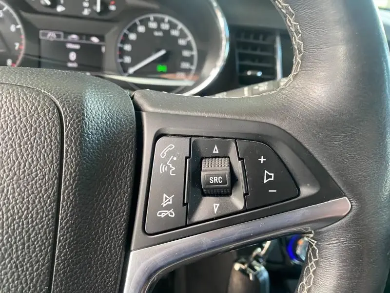 Gros plan sur les commandes audio et téléphone au volant en cuir noir de l'Opel Mokka 2017, version Cosmo.