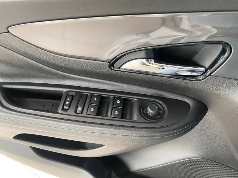 Vue rapprochée de la porte côté gauche de l'Opel Mokka 2017, montrant la poignée chrome et les commandes électriques noires.