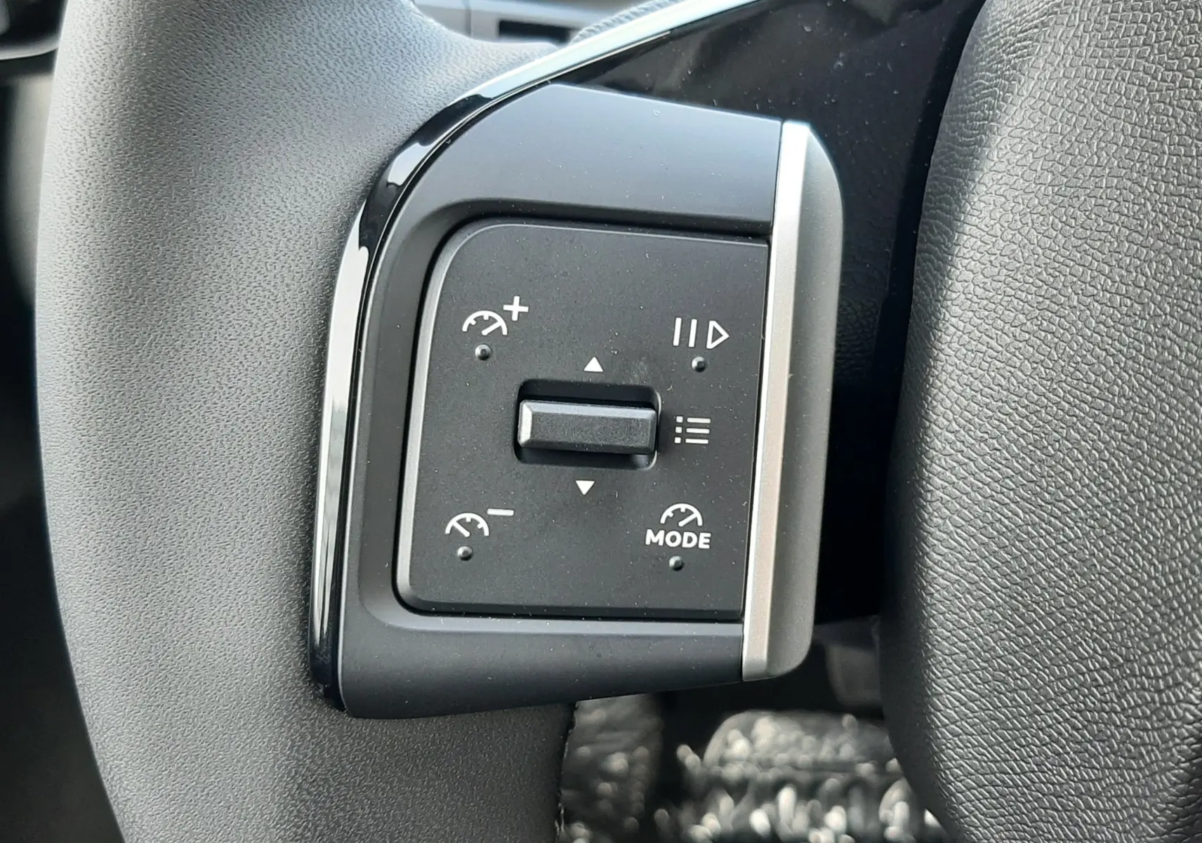 Gros plan sur les commandes de régulateur de vitesse au volant noir du Citroën C3 Aircross hybride 2026.