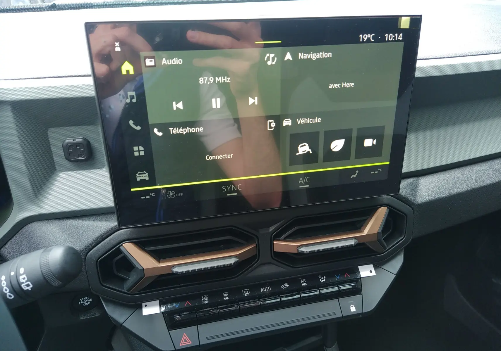 Écran tactile central et aérateurs au design hexagonal bronze dans l'habitacle du Dacia Bigster 2025.