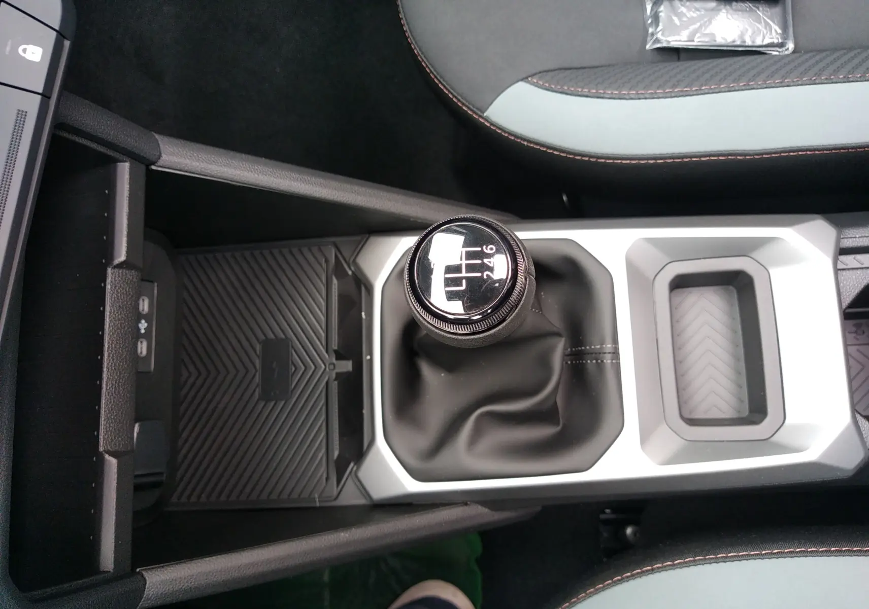 Vue plongeante sur la console centrale grise et noire du Dacia Bigster 2025, mettant en valeur le levier de vitesse manuel.