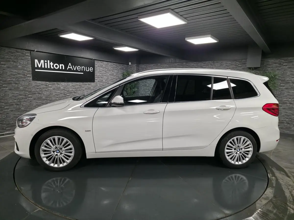 BMW Série 2 Gran Tourer blanc vue de profil côté gauche avec jantes alliage 17 pouces en intérieur showroom