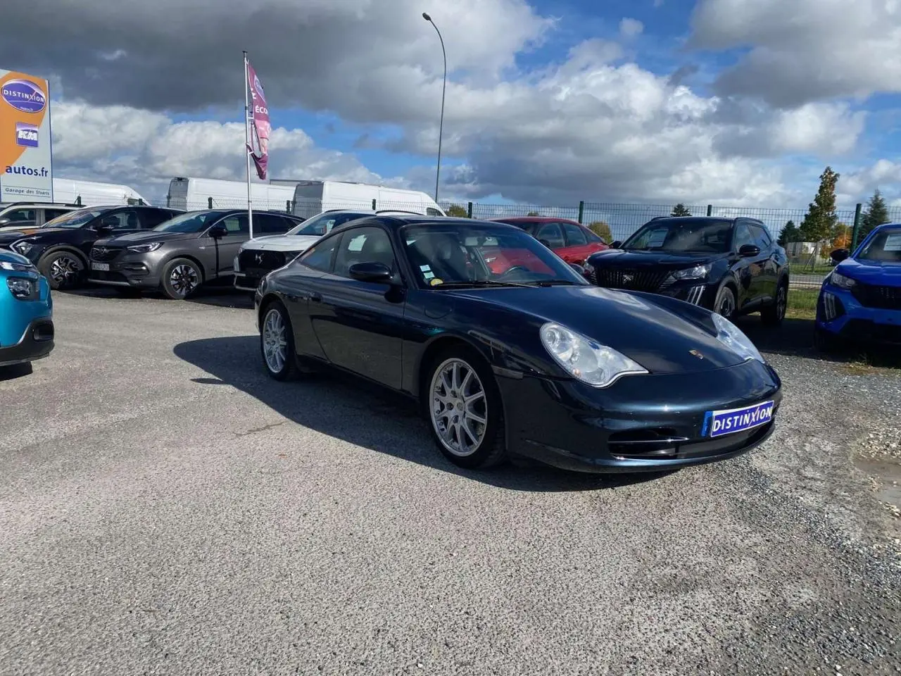Porsche 911 Targa 3.6i 2004 gris foncé vue 3/4 avant droit sur parking extérieur sous ciel nuageux.