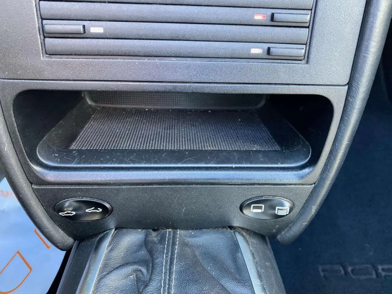 Gros plan sur la console centrale noire de la Porsche 911 Targa 3.6i 2004 avec levier de vitesses manuelle en cuir.