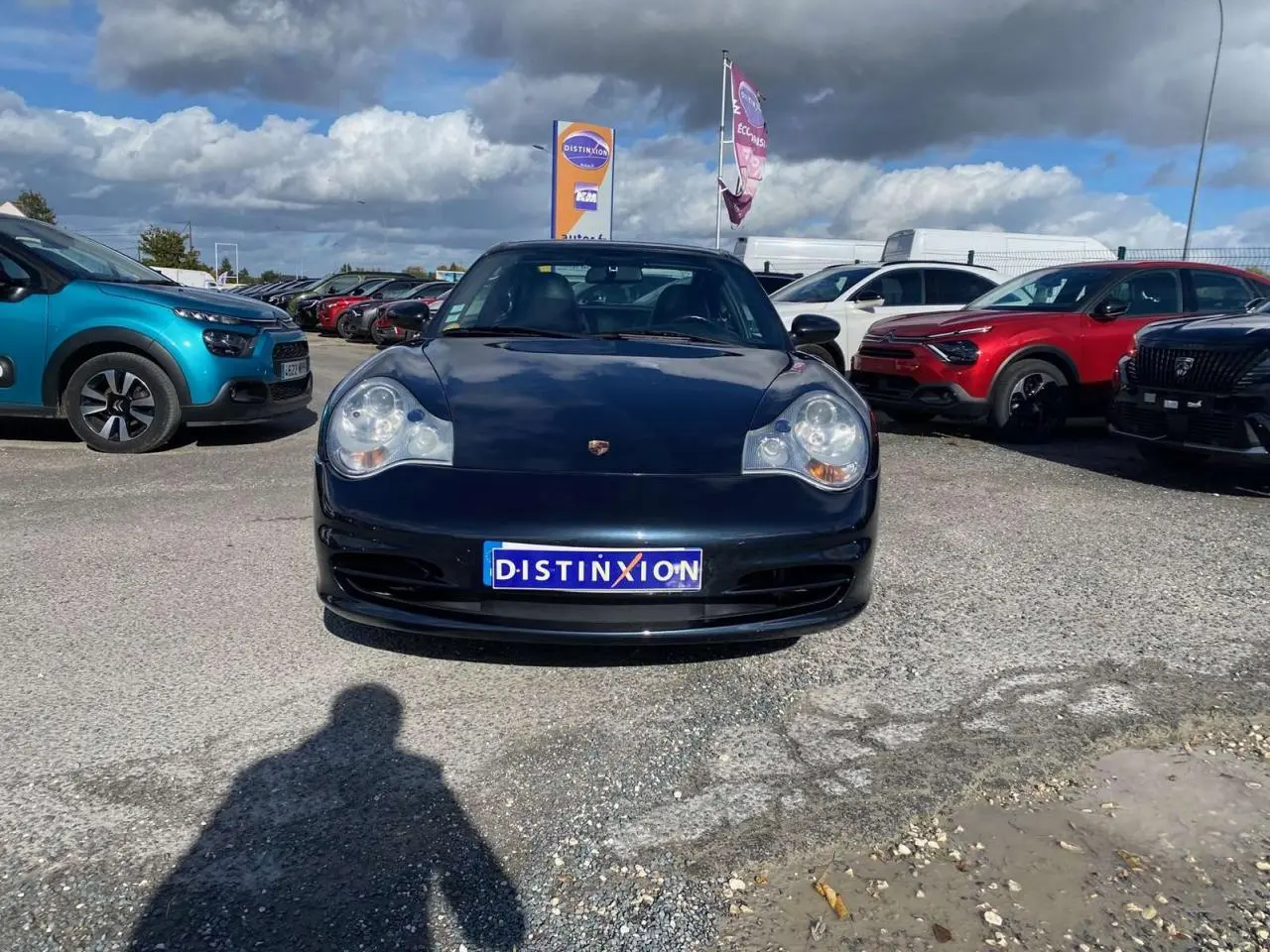 Vue avant d'une Porsche 911 Targa 3.6i 2004 gris foncé stationnée sur un parking ensoleillé.