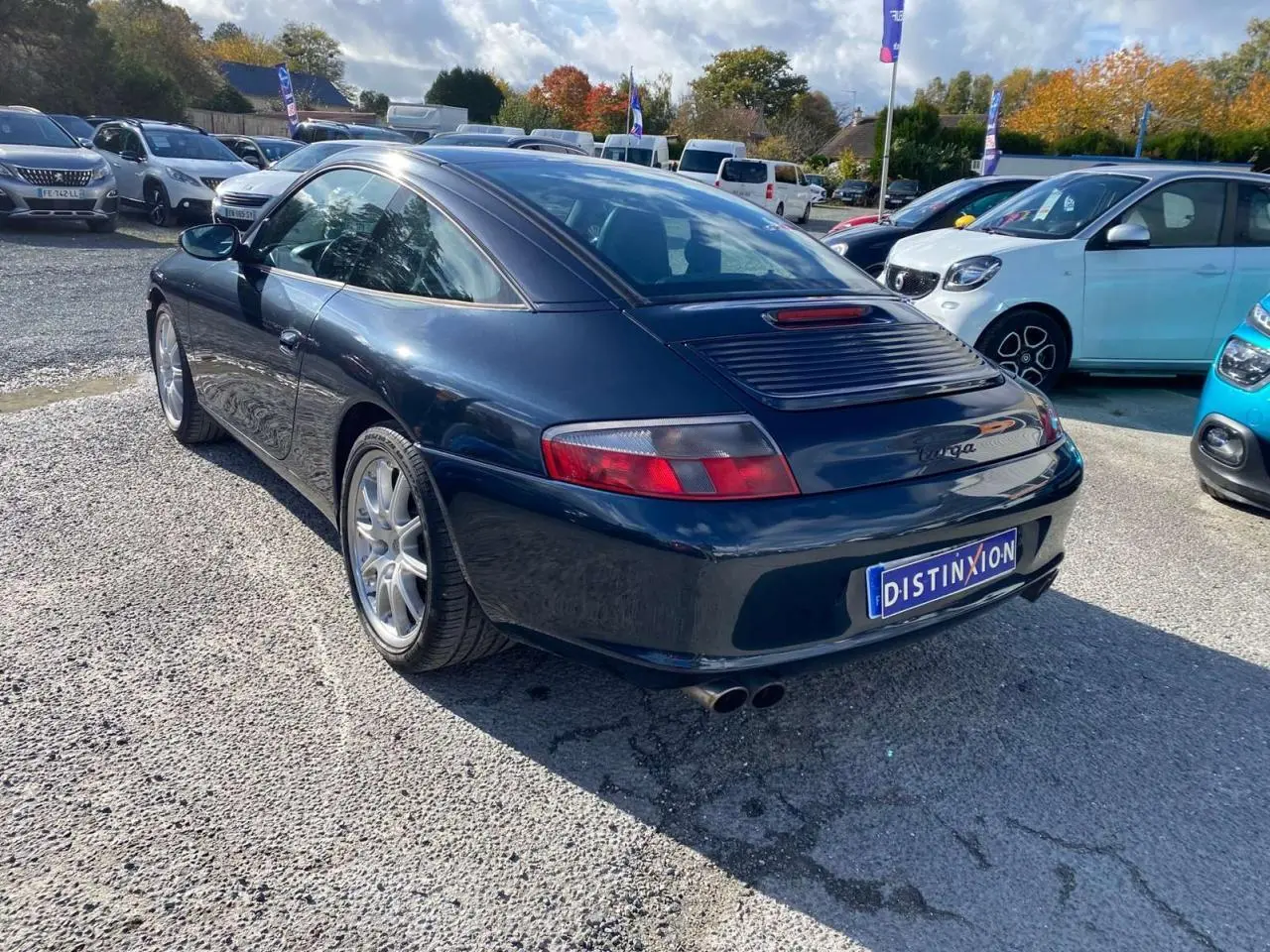 Vue 3/4 arrière droite d'une Porsche 911 Targa 3.6i gris foncé avec toit caractéristique Targa et double sortie d'échappement.