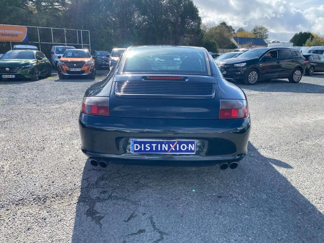 Vue arrière d'une Porsche 911 Targa 3.6i gris foncé de 2004 avec double sortie d'échappement et toit Targa visible.