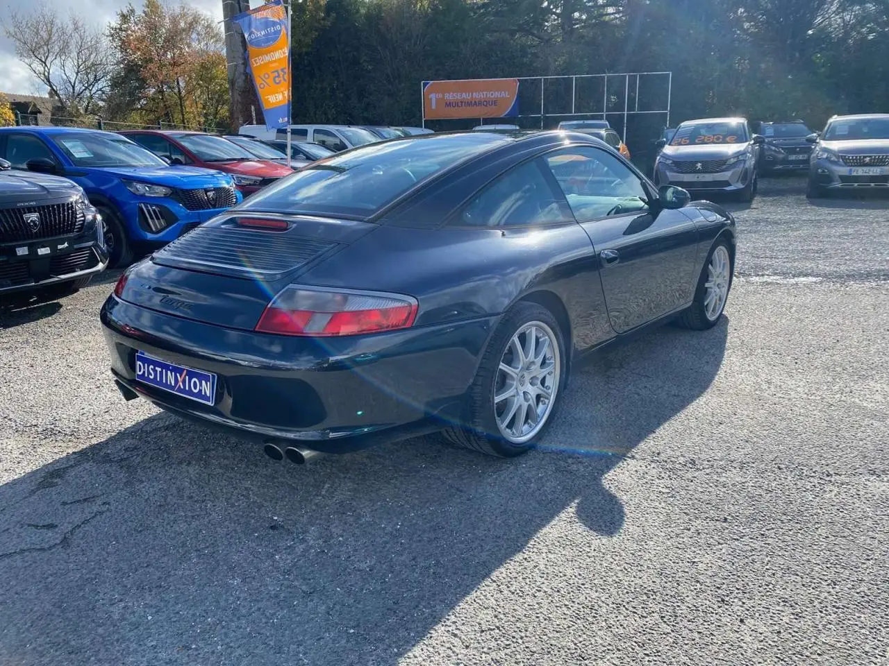 Vue 3/4 arrière droite d'une Porsche 911 Targa 3.6i gris foncé de 2004 avec toit rigide caractéristique Targa.