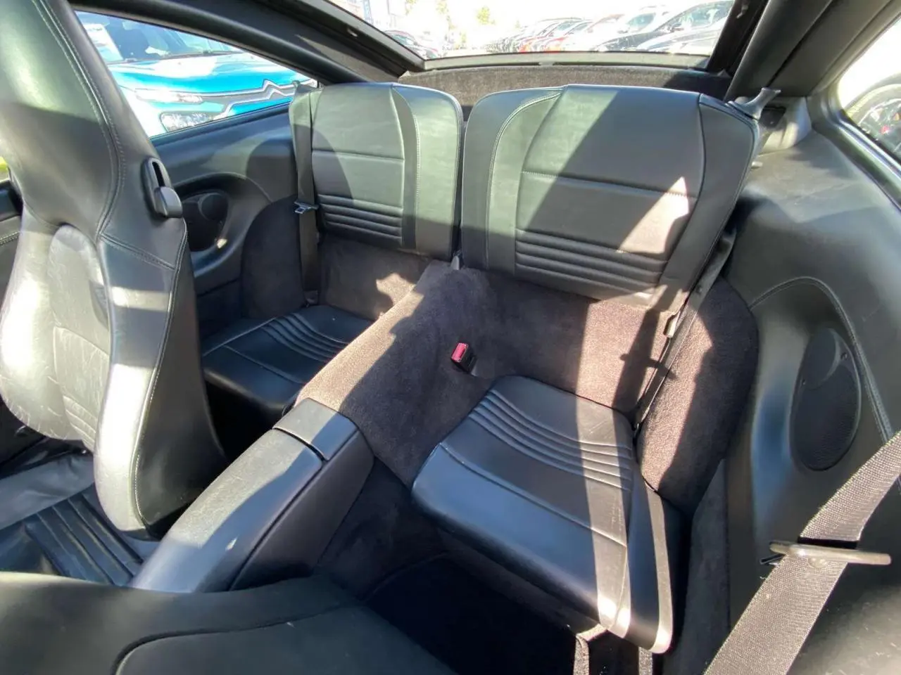Vue intérieure arrière montrant les sièges en cuir noir de la Porsche 911 Targa 3.6i gris foncé de 2004.