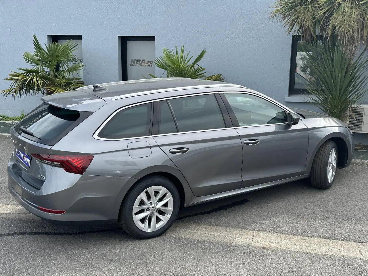 Vue de profil côté droit d'une Skoda Octavia Combi gris graphite avec feux arrière LED et vitres teintées.