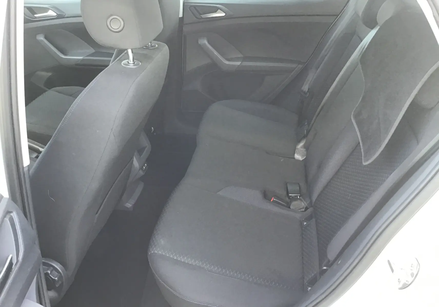 Vue intérieure côté droit montrant la banquette arrière noire du Volkswagen T-Cross blanc 2021.