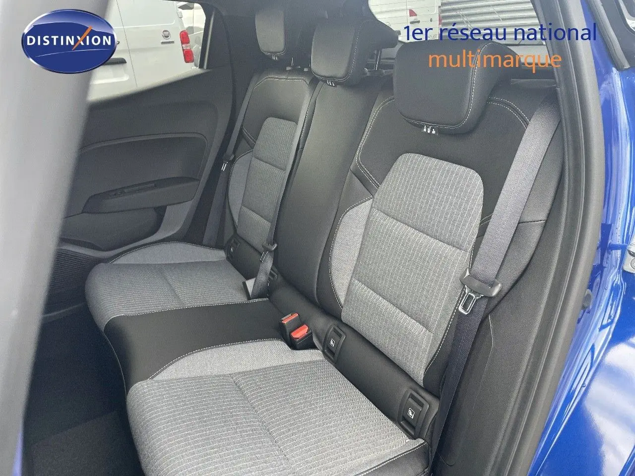 Vue intérieure sur les sièges arrière gris et noirs de la Renault Clio TCe 90ch Techno bleu Iron Metal, porte arrière ouverte.