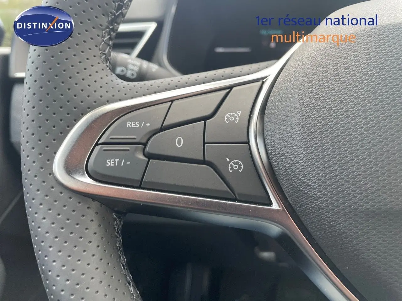 Gros plan sur les commandes de régulateur de vitesse au volant perforé d'une Renault Clio TCE 90CH TECHNO 2025.