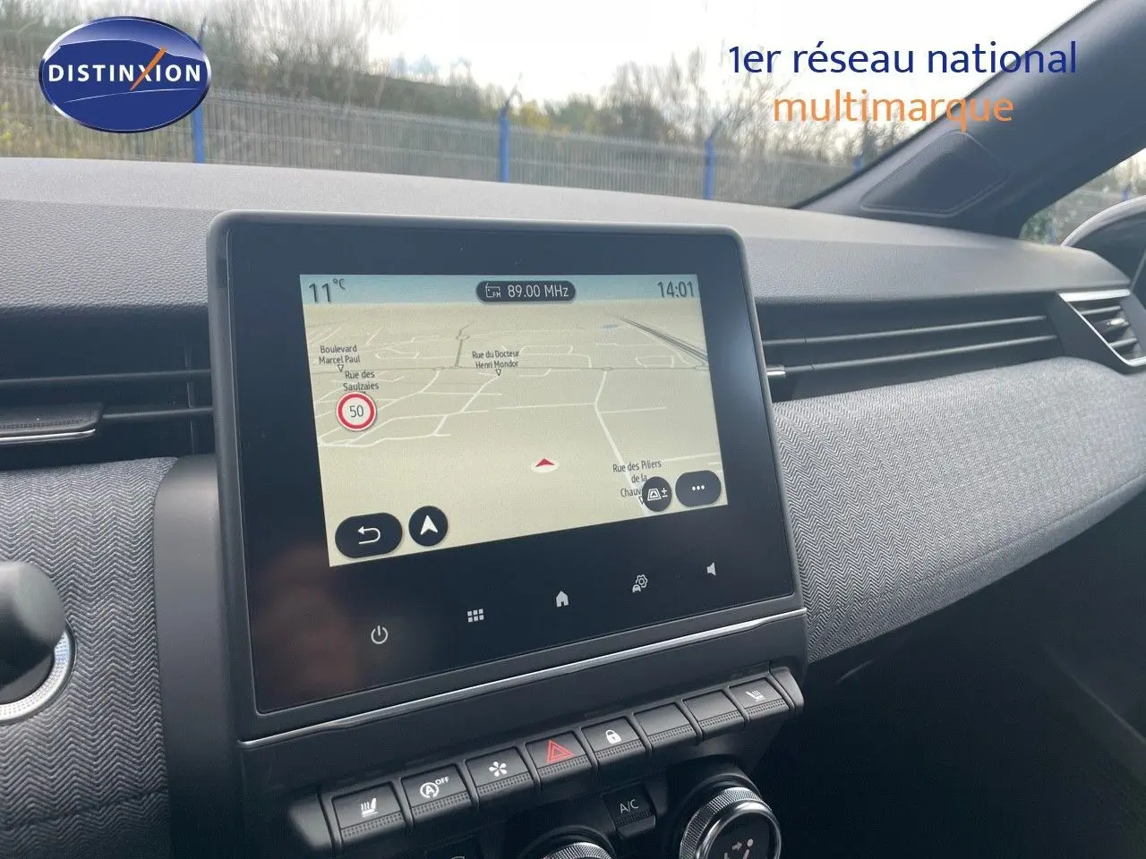 Écran tactile central affichant la navigation dans l'habitacle moderne d'une Renault Clio bleu iron metal.