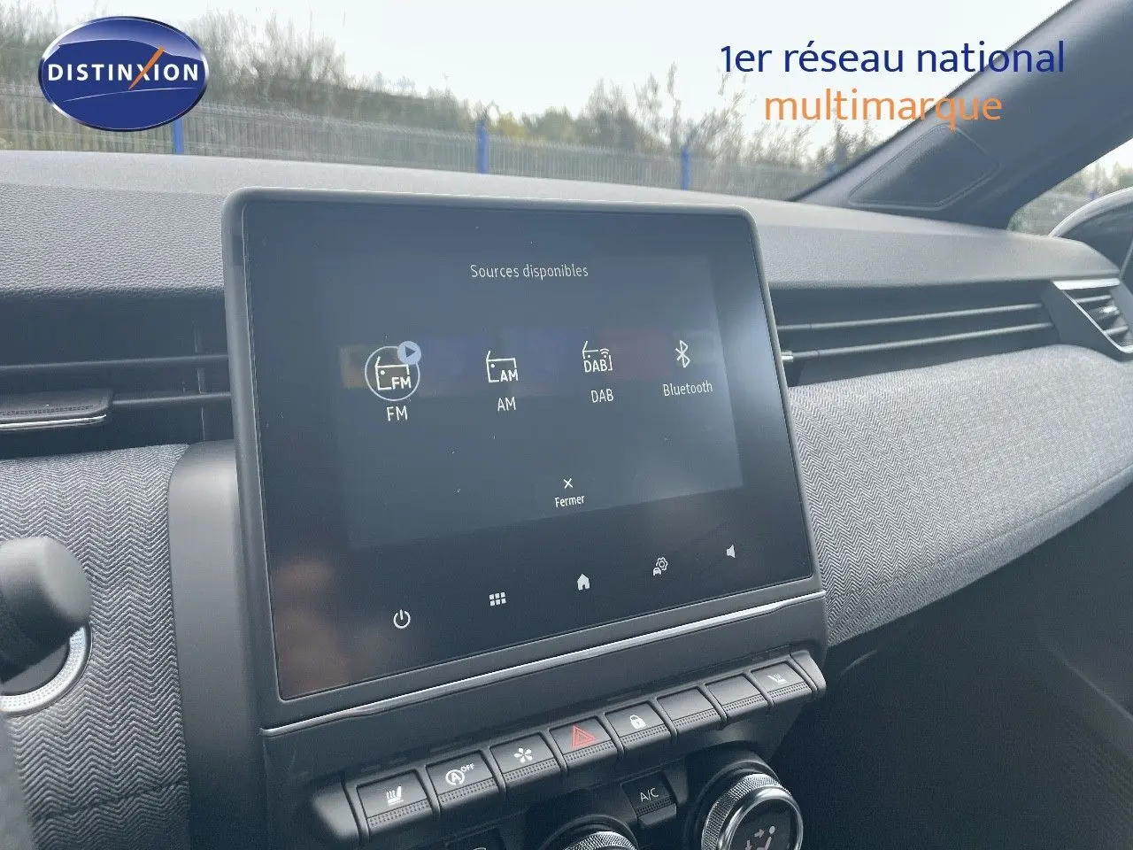Vue intérieure du tableau de bord de la Renault Clio TCe 90ch Techno 2025 avec écran tactile et commandes de climatisation.