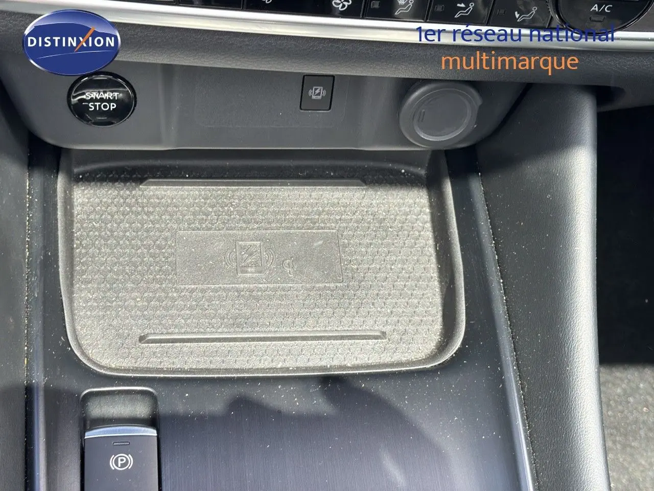 Gros plan sur la console centrale du Nissan Qashqai noir 2024, avec bouton start/stop et zone de charge sans fil.