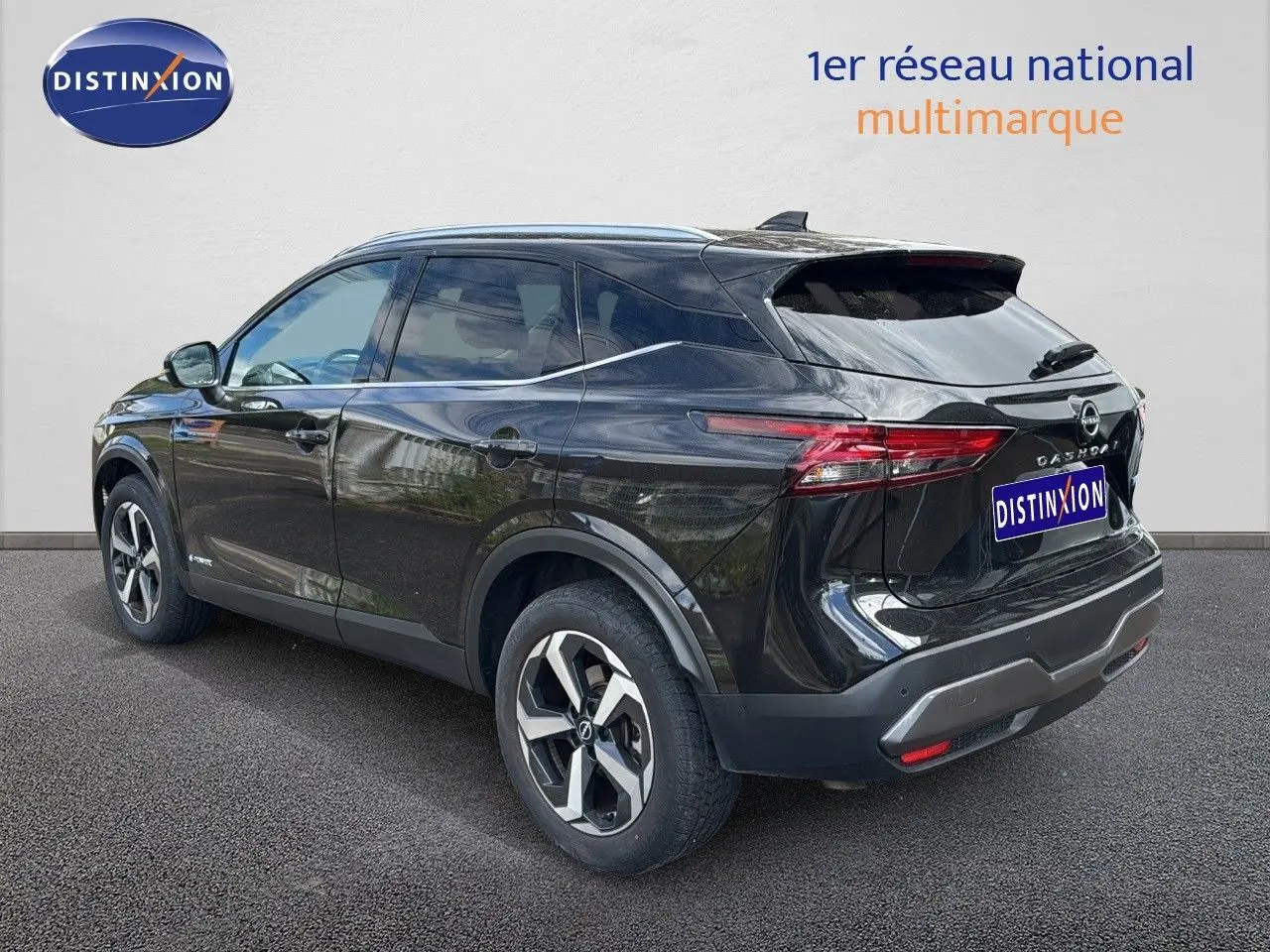 Nissan Qashqai noir 2024 vu 3/4 arrière côté gauche, avec jantes bi-ton et feux arrière LED distinctifs.