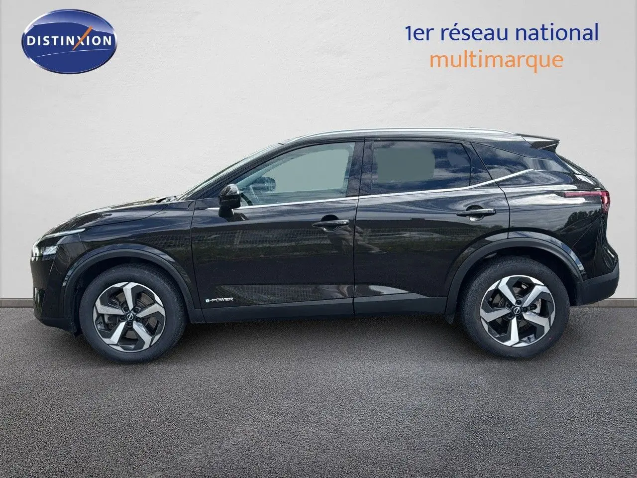 Profil côté gauche d'un Nissan Qashqai noir 2024 hybride e-Power avec jantes bi-ton et lignes épurées.