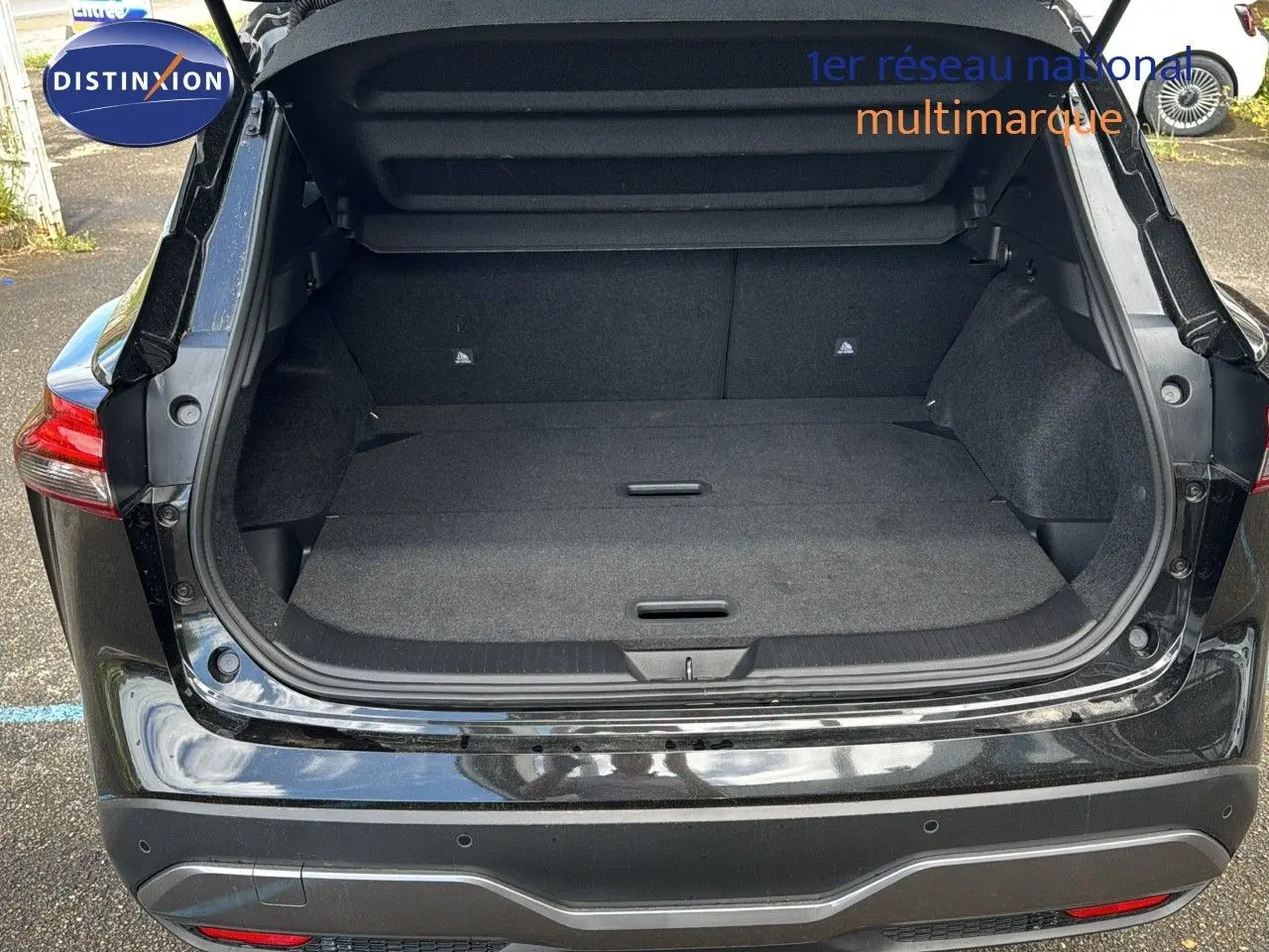 Coffre ouvert en vue arrière d'un Nissan Qashqai noir 2024, montrant un espace de chargement spacieux et propre.