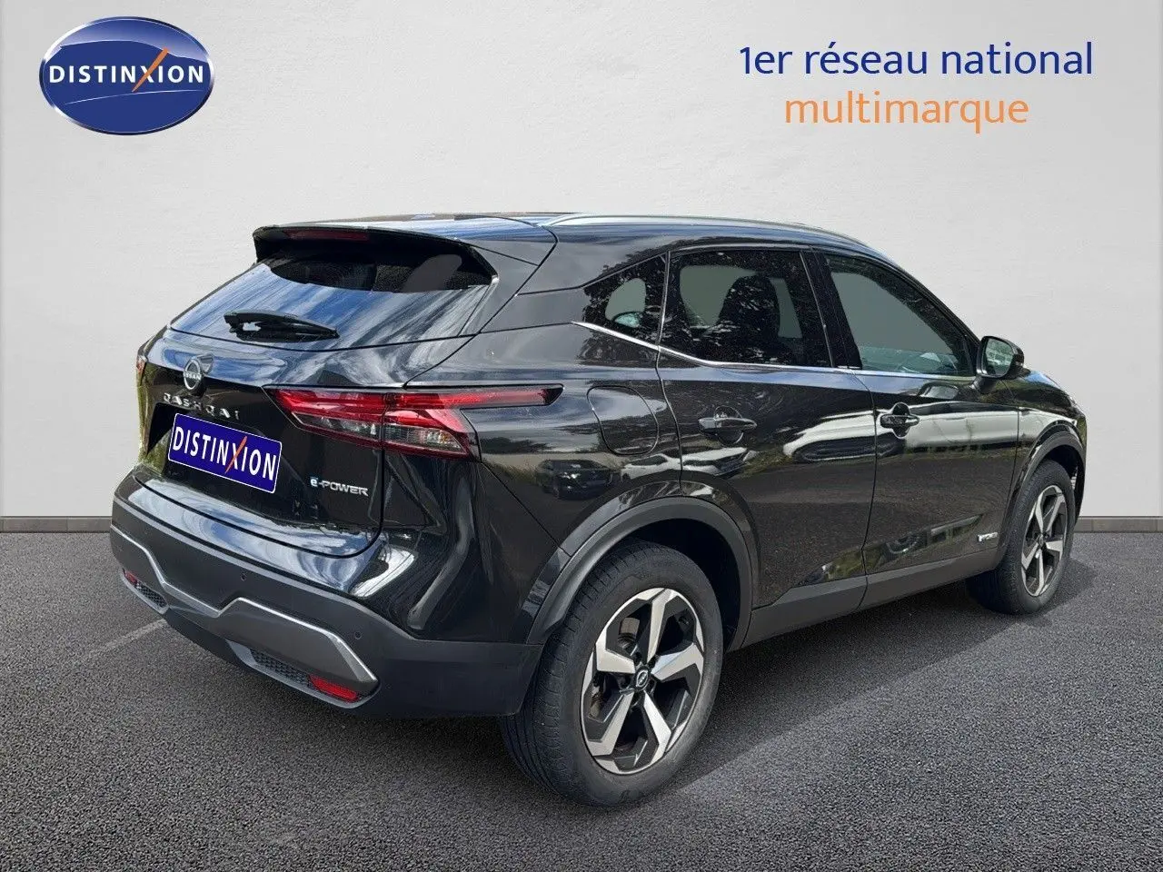 Nissan Qashqai noir en 3/4 arrière côté gauche, mettant en valeur ses feux effilés et jantes bi-ton modernes.