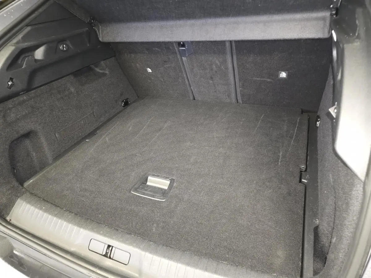 Coffre spacieux du Peugeot 3008 gris, vue intérieure arrière avec plancher modulable et revêtement tissu noir.