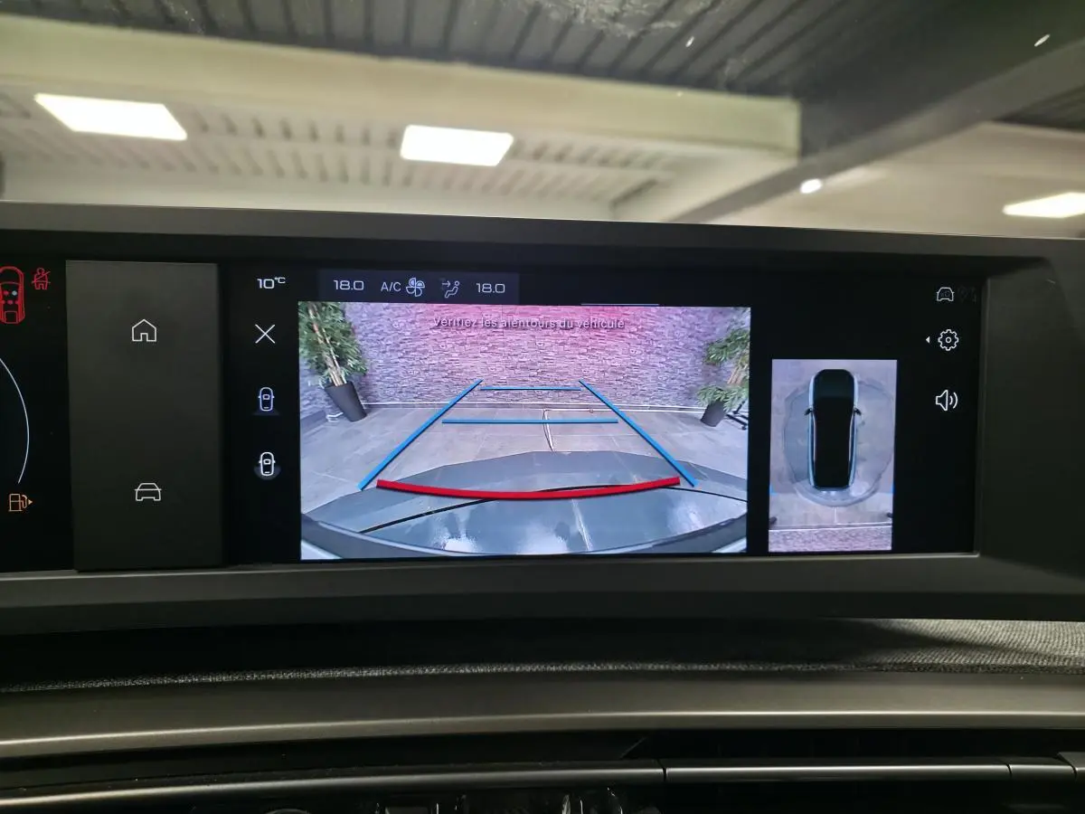 Écran de recul du Peugeot 3008 gris 2025 montrant la caméra arrière et la vue 360° du véhicule en stationnement.