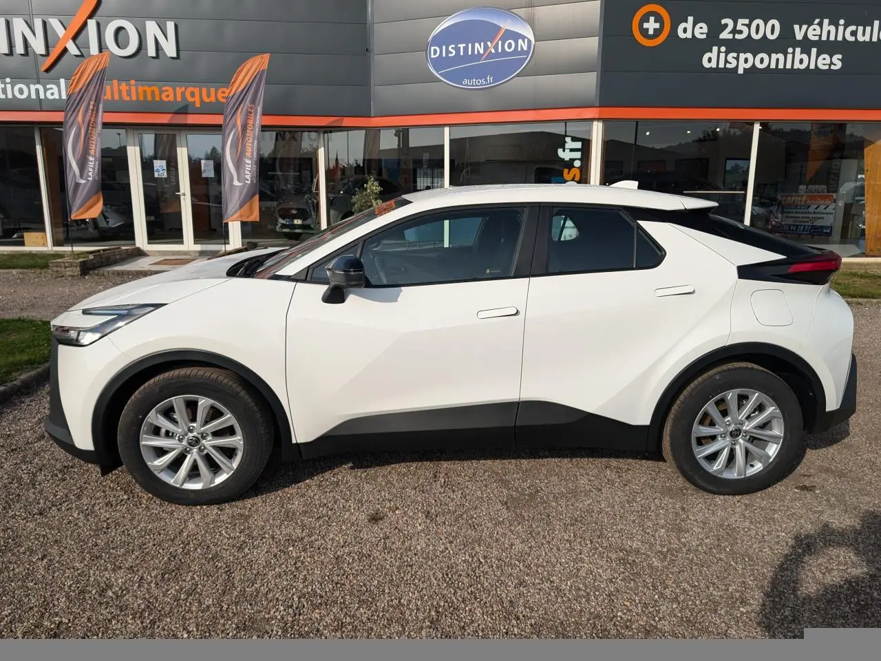 Profil droit du Toyota C-HR blanc 2024, version hybride, avec jantes alliage 17 pouces et poignées affleurantes.