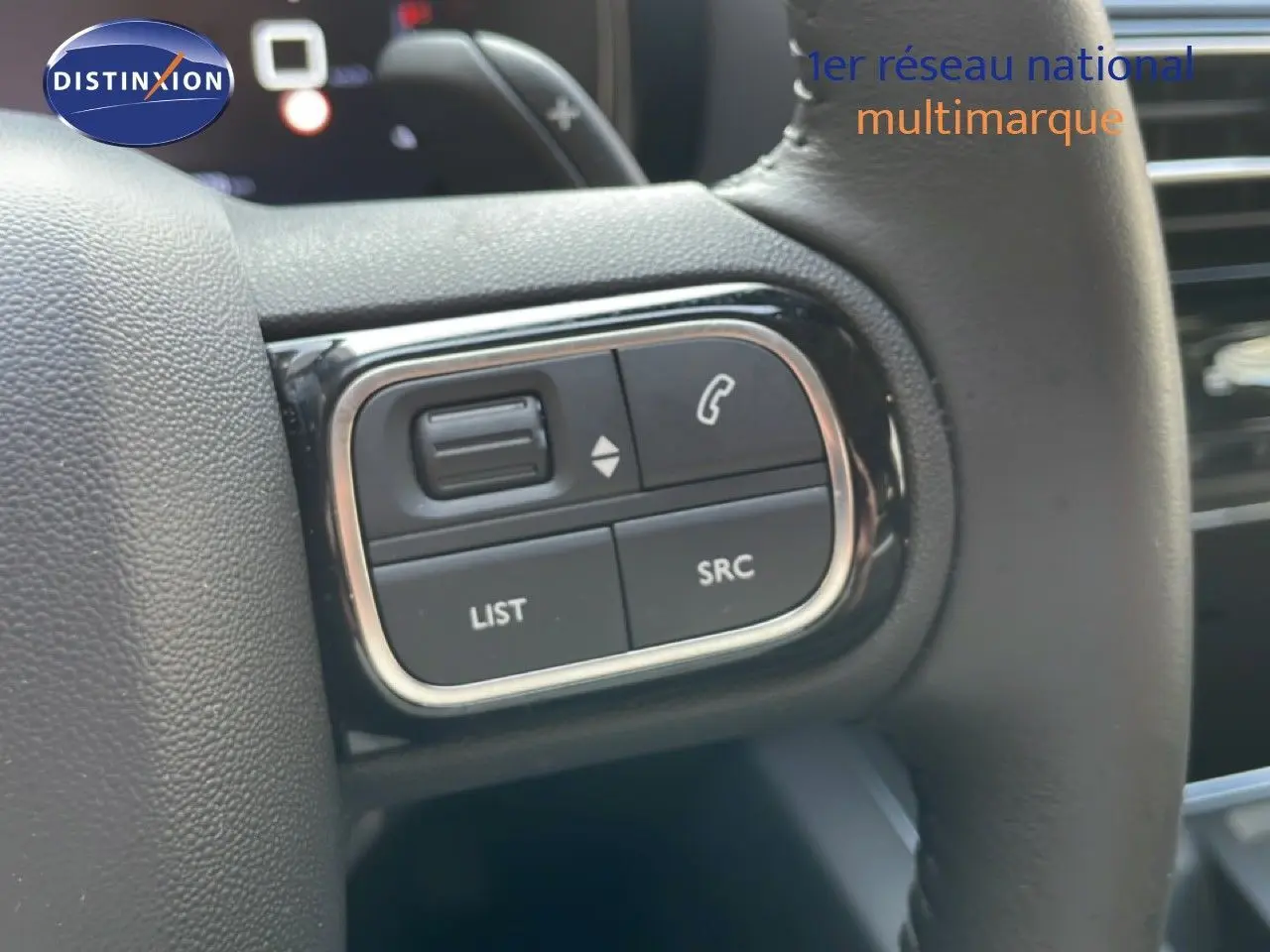 Gros plan sur les commandes gauche du volant du Citroën C5 Aircross 2025 en intérieur gris noir.
